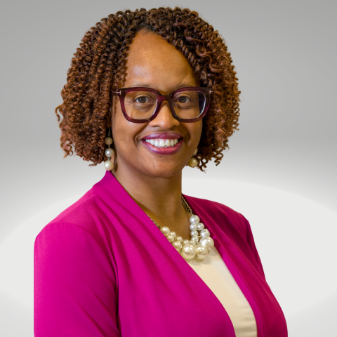 Headshot of Angela McKnight wearing a vibrant pink suit